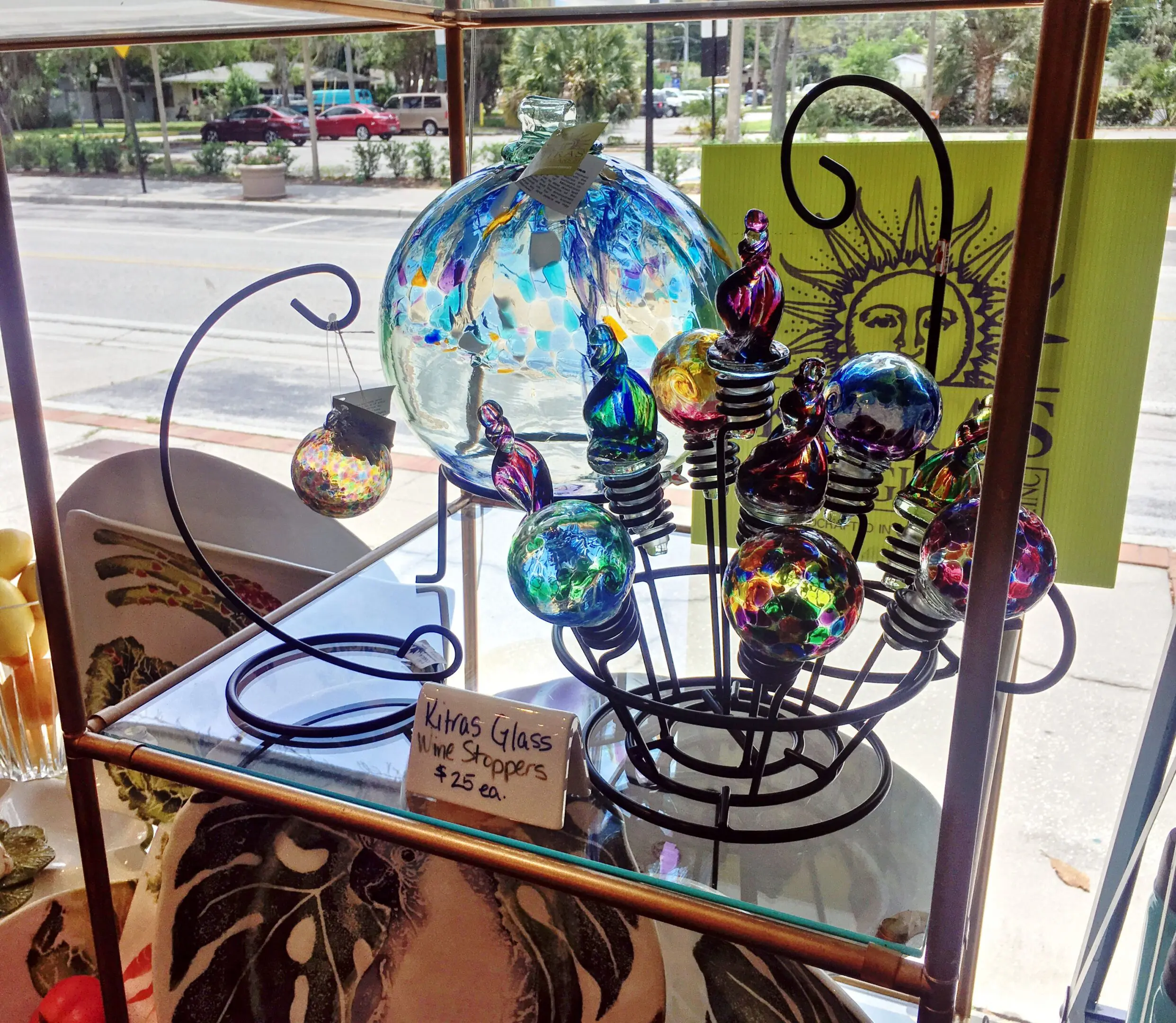 Colorful glass wine stoppers on display shelf.