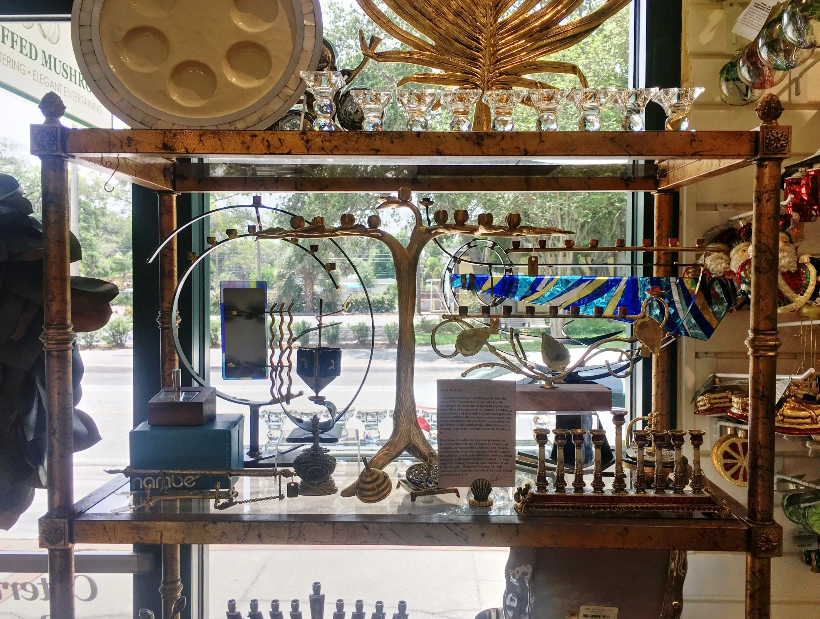 Display shelf with various menorahs and items.