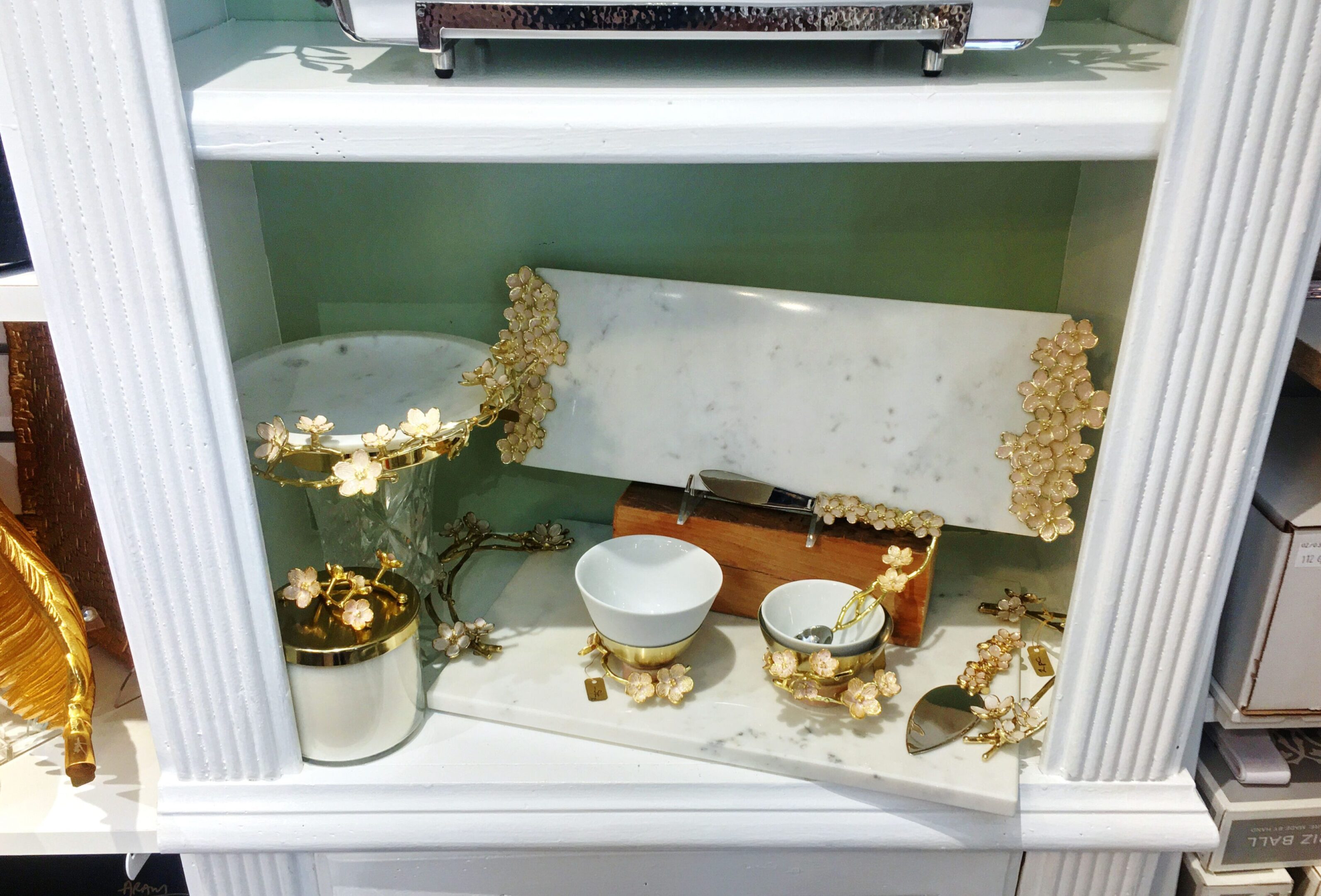 Elegant kitchenware with floral gold accents displayed.
