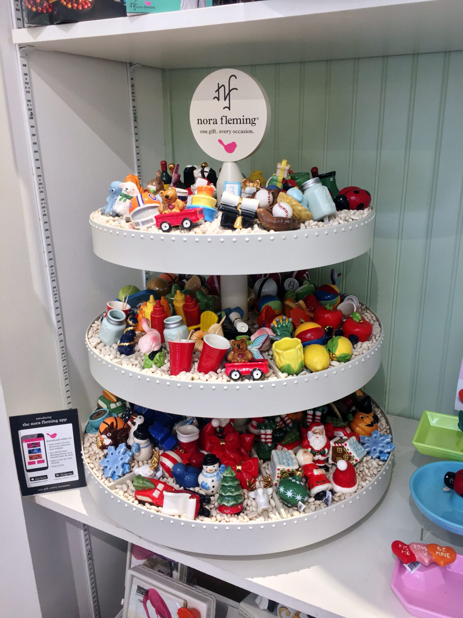 Tiered display with colorful miniatures and ornaments.