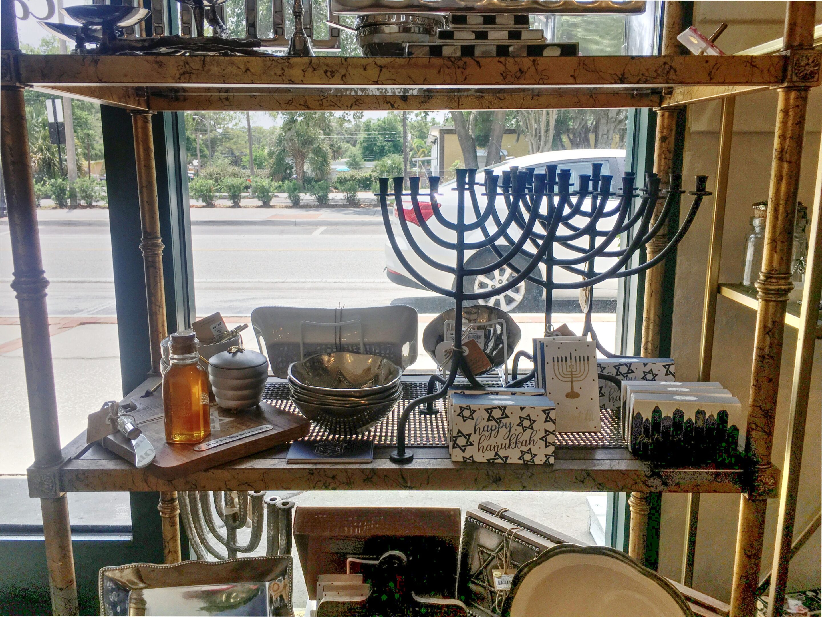 Store shelf with menorahs and various items.